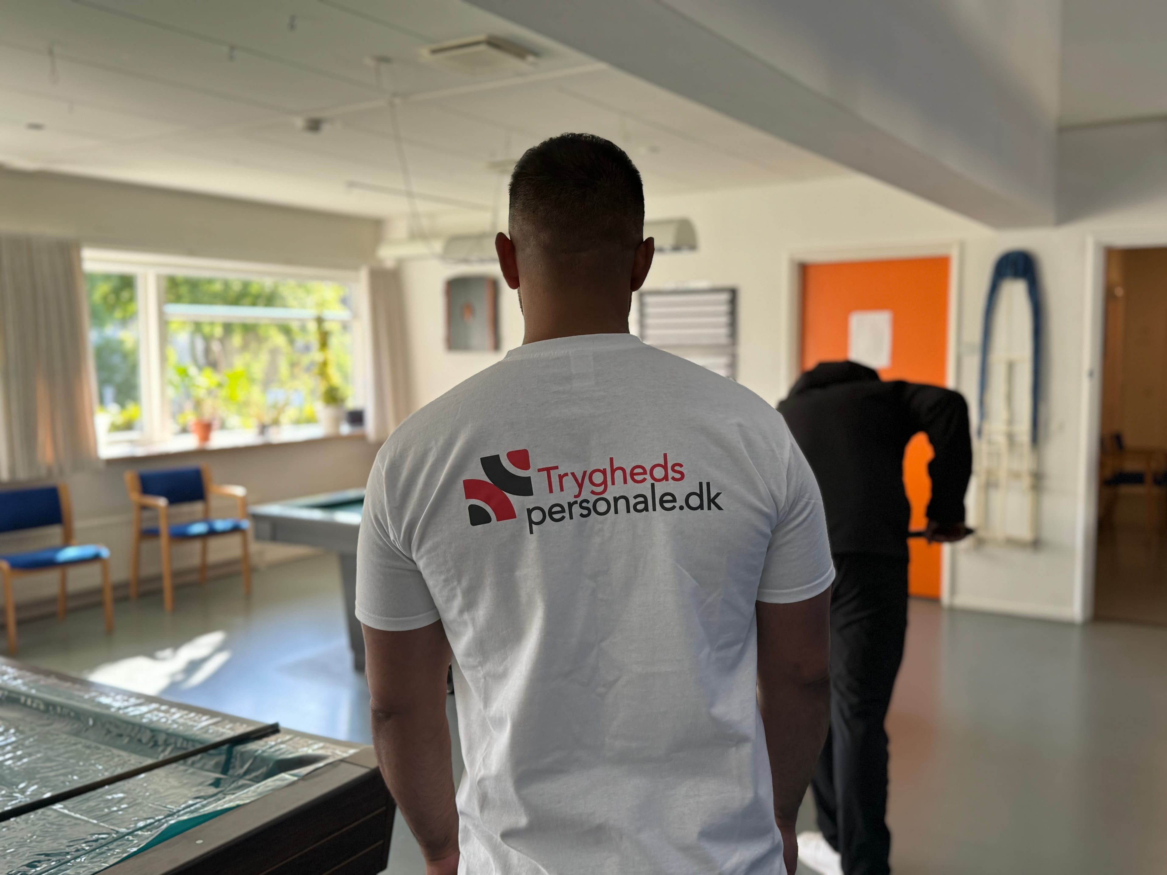 Tryghedspersonale medarbejder spiller billard med borger - professionel støtte i aktiviteter